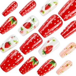 Set di unghie finte a tema fragola con motivi a pois rossi e floreali su sfondo bianco