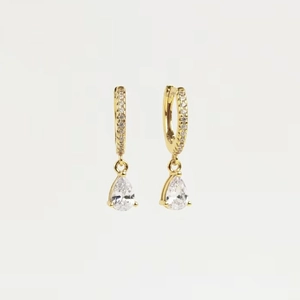 Golden drop earrings with teardrop gemstones and micro-pave crystals on white background
