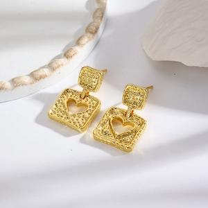 Detail showing vintage gold square earrings with hollow heart shape and hammered texture