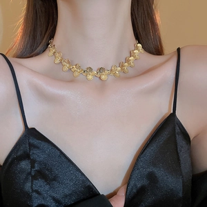 Close-up of a gold flower necklace worn by a model showcasing detailed luxury craftsmanship