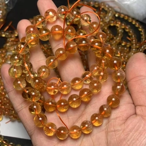 Stack of natural yellow citrine bead bracelets shown in a detailed handheld close-up