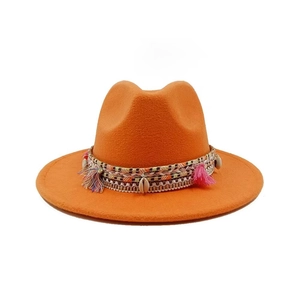 Detail of orange felt fedora featuring woven band with shell accents and colorful tassels