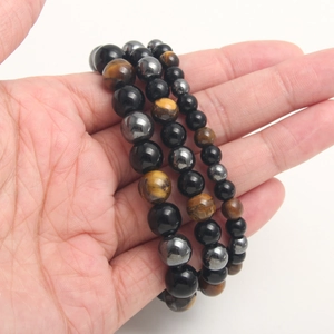 Detailed close-up of beaded bracelet with tiger eye and hematite stones on wrist