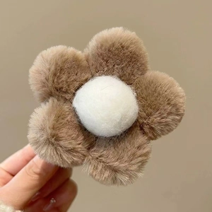Macro shot of brown plush flower hair clip with white core and fuzzy texture