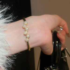 Détail d'un bracelet jonc plaqué or 18 carats avec disques étincelants de zircons