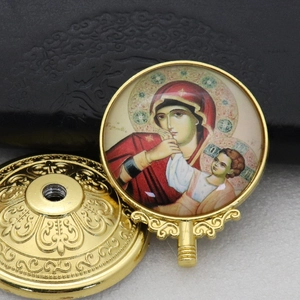 Close-up of golden metal religious icon featuring Mary and Jesus with embossed details