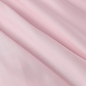 Detailed macro view of light pink fabric texture with natural folds and matte finish