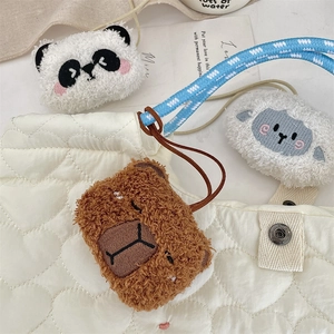 Dettaglio di ciondoli in peluche e borsa trapuntata a cuore con morbidi ricami