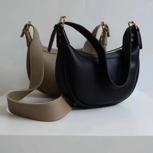 Detailed shot of crescent moon bags in black and khaki with gold hardware buckles