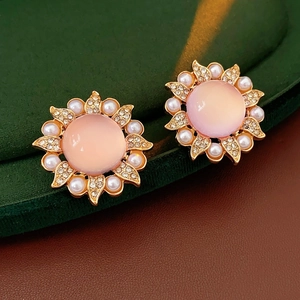 Détail macro de boucles d'oreilles tournesol vintage avec gemme rose et perles