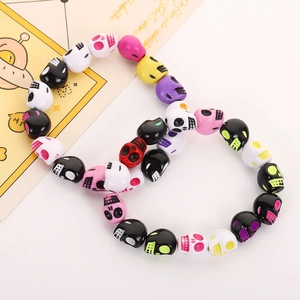 Close-up of colorful acrylic skull beads arranged in a figure-eight shape for DIY jewelry