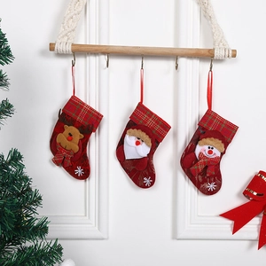 Three Christmas stockings with 3D Santa, Reindeer and Snowman on a wooden rack decor