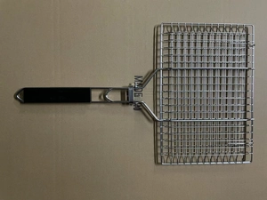 Detail of a square stainless steel grill pan with holes and a black handle for BBQ