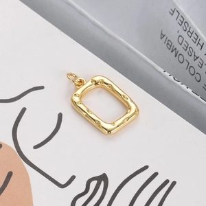Detailed close-up of a 18K gold-plated rectangular pendant with textured dotted edges