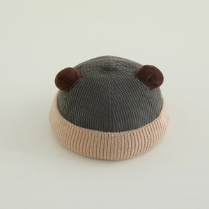 Detail of baby bear ear knitted hat showing grey and beige contrast ribbed texture