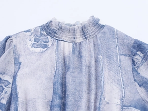 Détail de col montant smocké avec bord à volants et imprimé tie-dye bleu sur robe mousseline