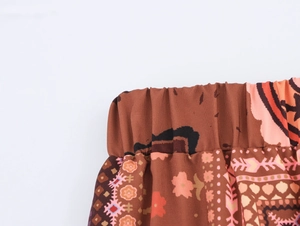 Close-up of the elastic waistband on brown floral print wide-leg vacation trousers