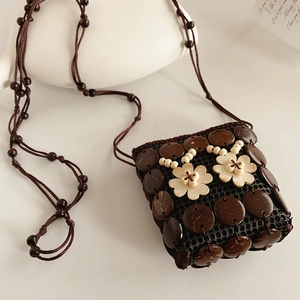 Détail d'un sac bandoulière fait main en coque de coco avec fleurs en bois et bandoulière