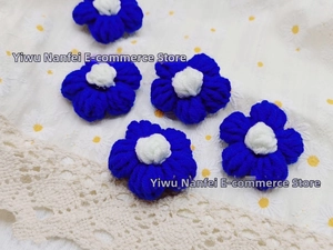 Detailed close-up of five handcrafted crochet navy blue and white cotton yarn flowers