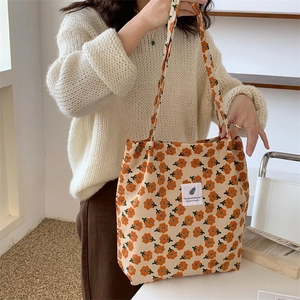 Detail of vintage floral corduroy tote bag showing orange patterns and interior pocket