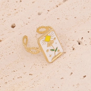 Adjustable golden lovers tarot ring with white enamel sun and rose on stone background