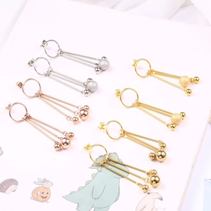Detail of tassel drop earrings in gold, silver, and rose gold with metallic sphere charms