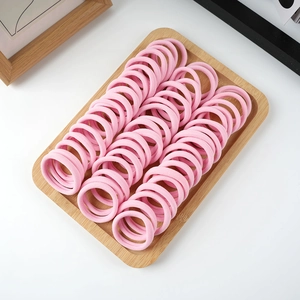 Detailed view of elastic pink hair ties neatly organized on a wooden display tray