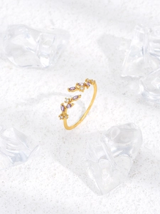 Detailed macro shot of adjustable gold leaf ring with purple marquise zirconia accents