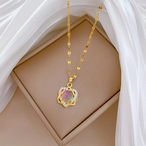 Macro view of gold flower necklace with purple gemstone and pavé zirconia on silk