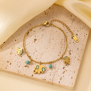 Detalle de los dijes de elefante dorado y cuentas turquesas en pulsera de acero inoxidable
