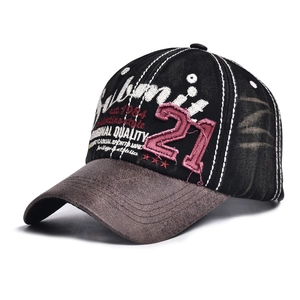 Close-up of vintage embroidery and distressed detail on black and brown baseball cap