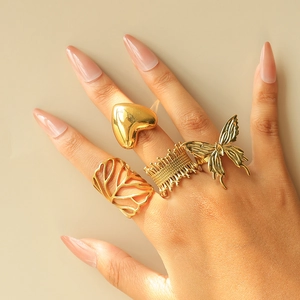 Set of four gold stainless steel rings featuring heart, butterfly and leaf motifs