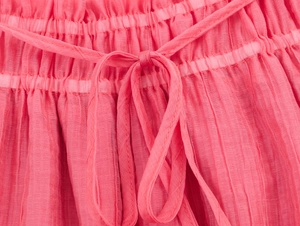 Close-up of pink bohemian style pleated skirt showing elastic waist with drawstring detail