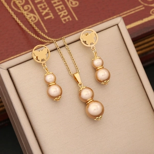 Detail of golden butterfly and double champagne pearl jewelry set on a display case