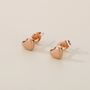 Vue détaillée des boucles d'oreilles cœur en or rose avec finition miroir polie