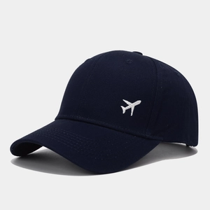 Détail de la broderie avion blanc sur une casquette de baseball bleu marine