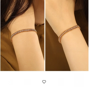 Detail of elegant gold-plated double-row crystal chain bracelet on model's wrist