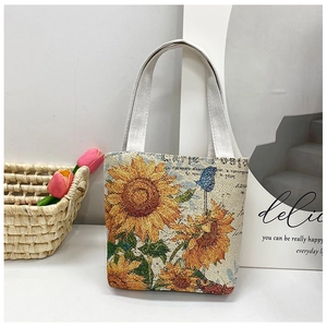 Detail of vibrant sunflower embroidery on a small canvas handbag with cotton straps