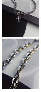 Detailed macro view of dual-layer titanium steel cross necklace with silver Cuban chain