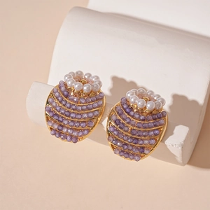 Vintage floral pearl earrings with purple beads and gold metal trim on white stone