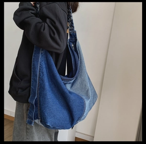 Detail of blue denim patchwork hobo bag with braided strap and durable metal zipper