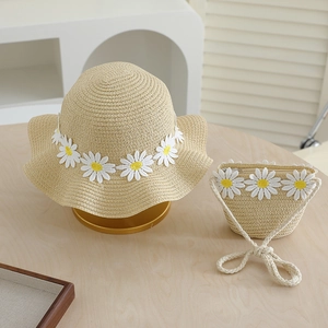 Detailed close-up of straw hat and matching bag with 3D white daisy floral decorations