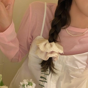 Détail d'un chouchou en dentelle rose avec bordure florale sur un chignon de style coréen