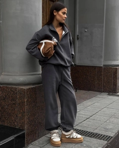 Survêtement gris foncé à demi-zip porté avec sac en peluche marron et bottes à plateforme