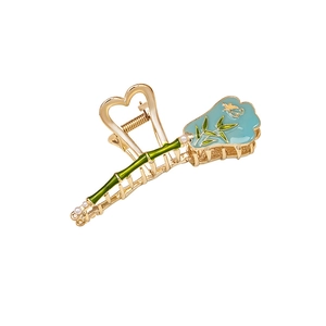 Elegant gold metal hair claw clip with bamboo design and blue fan-shaped charm