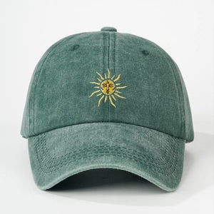 Detailed embroidery of a sun smiley face on a washed green cotton baseball cap