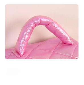 Detail of pink glossy quilted cosmetic bag with padded handle and diamond stitching