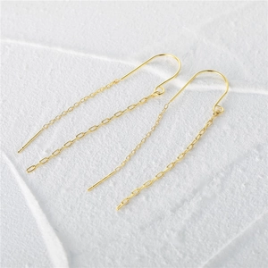Macro shot of S925 sterling silver stamp on golden tassel earrings with long chains