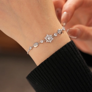 Close-up of elegant silver flower bracelet with sparkling zircons on a model wrist