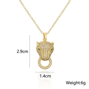 Detail view of 18K gold leopard head pendant with clear zircons and green eyes